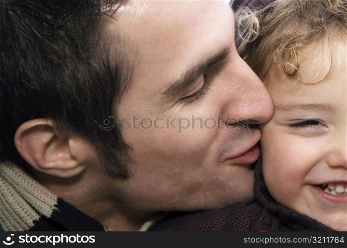 Close-up of a young man kissing his daughter