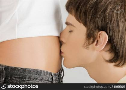 Close-up of a young man kissing on a young woman&acute;s abdomen