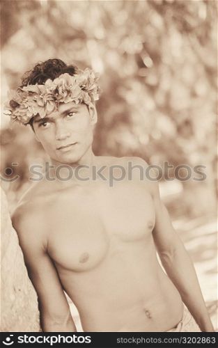 Close-up of a young man leaning against a tree, Hawaii, USA