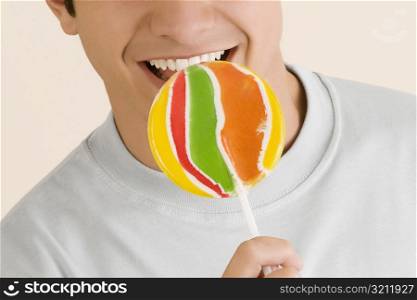 Close-up of a young man licking a lollipop