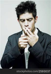 Close-up of a young man lighting a cigarette with a cigarette lighter