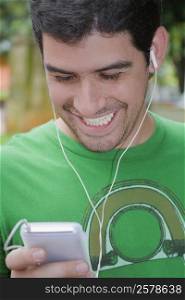 Close-up of a young man listening to an MP3 player