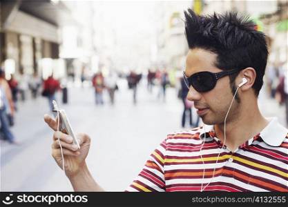 Close-up of a young man listening to an MP3 Player