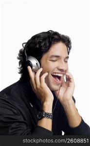 Close-up of a young man listening to music and laughing