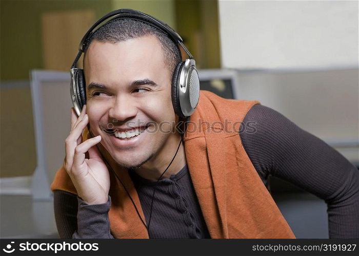 Close-up of a young man listening to music and smiling