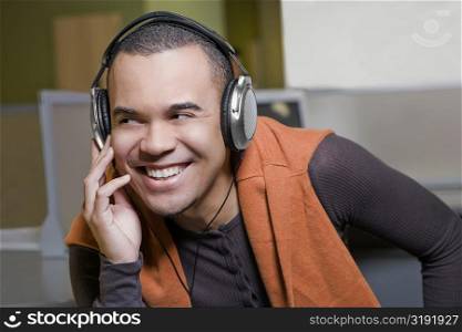 Close-up of a young man listening to music and smiling