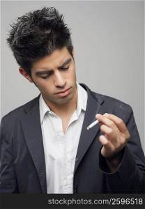 Close-up of a young man looking at a burning cigarette