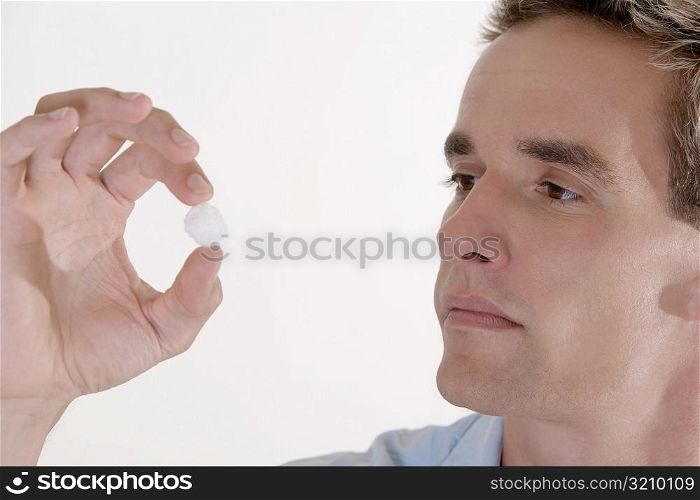 Close-up of a young man looking at a cotton ball