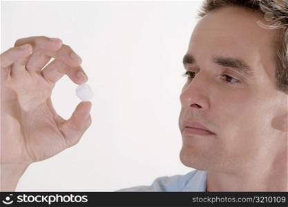Close-up of a young man looking at a cotton ball