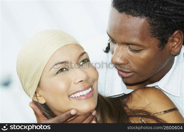 Close-up of a young man looking at a young woman and smiling