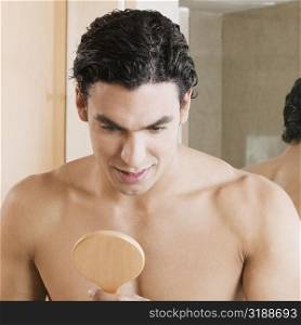 Close-up of a young man looking into a mirror