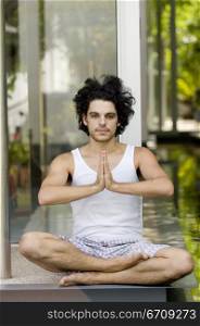 Close-up of a young man meditating in a lotus position