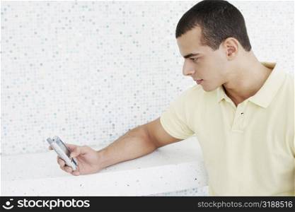 Close-up of a young man operating a mobile phone