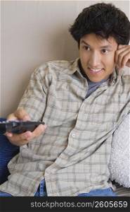 Close-up of a young man operating a remote control