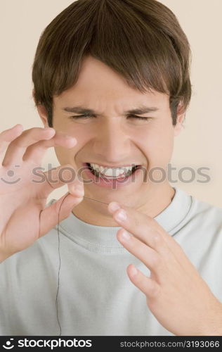 Close-up of a young man pinching a needle in his finger