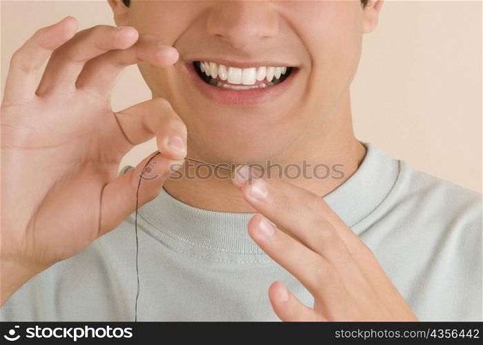 Close-up of a young man pinching a needle in his finger