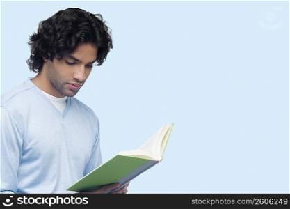 Close-up of a young man reading a book