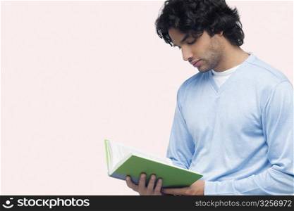 Close-up of a young man reading a book