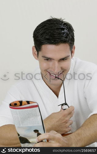 Close-up of a young man reading a magazine