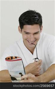 Close-up of a young man reading a magazine