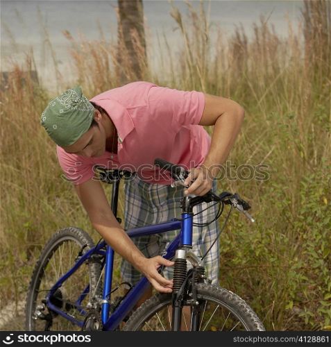 Close-up of a young man repairing his bicycle