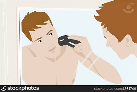 Close-up of a young man shaving with an electric razor