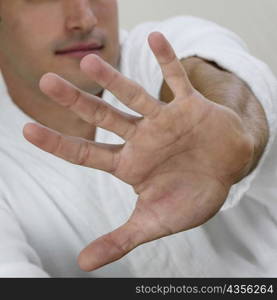 Close-up of a young man showing a stop gesture