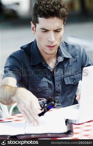 Close-up of a young man sitting and using a laptop