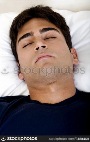 Close-up of a young man sleeping on a bed