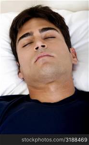 Close-up of a young man sleeping on a bed