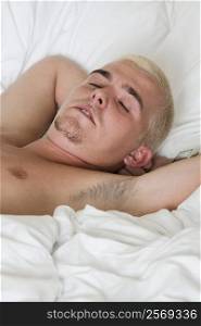 Close-up of a young man sleeping on the bed