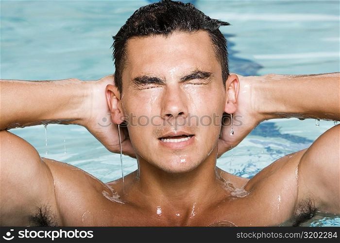 Close-up of a young man splashing water in a swimming pool
