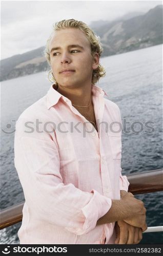 Close-up of a young man standing on a boat deck
