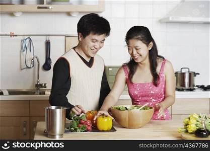 Close-up of a young man standing with a mid adult woman in the kitchen