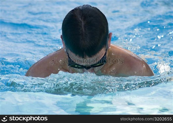 Close-up of a young man swimming in a swimming pool