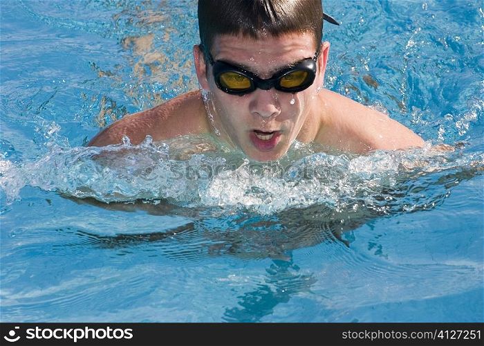 Close-up of a young man swimming in a swimming pool