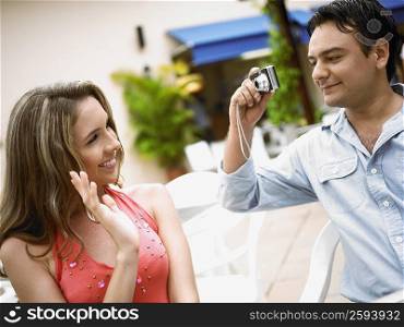 Close-up of a young man taking a picture of a young woman