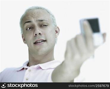 Close-up of a young man taking a self portrait with a digital camera