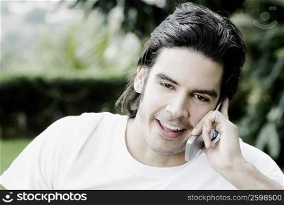 Close-up of a young man talking on a mobile phone and smiling