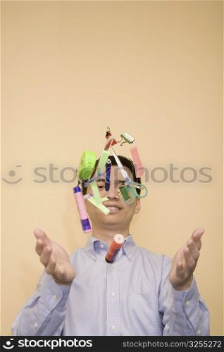 Close-up of a young man tossing stationery objects