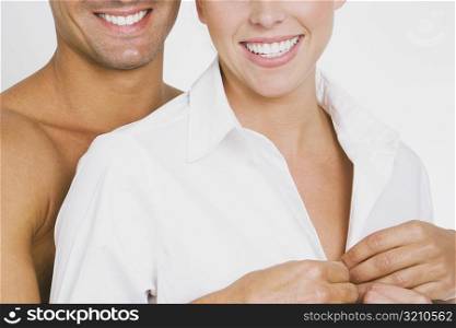 Close-up of a young man undressing a young woman