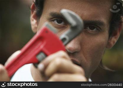 Close-up of a young man using an adjustable wrench