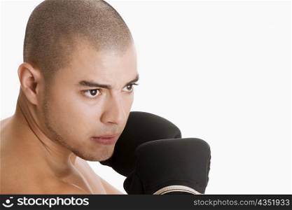 Close-up of a young man wearing boxing gloves