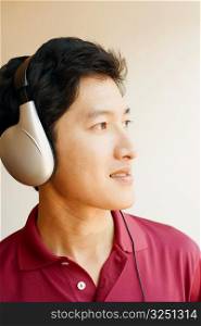 Close-up of a young man wearing headphones and listening to music