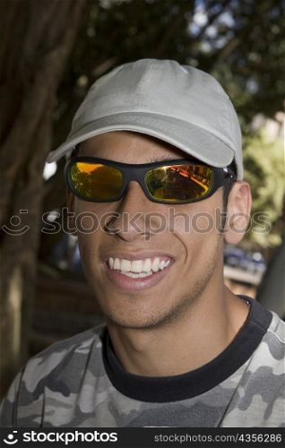 Close-up of a young man wearing sunglasses and smiling