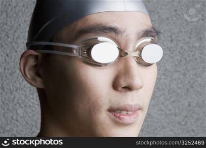 Close-up of a young man wearing swimming goggles