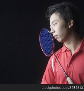 Close-up of a young man with a badminton racket