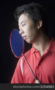 Close-up of a young man with a badminton racket