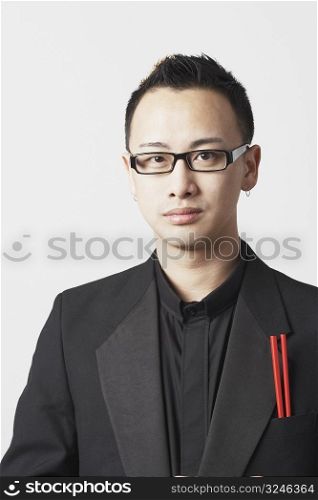 Close-up of a young man with chopsticks in his pocket