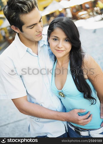 Close-up of a young man with his arm around a teenage girl